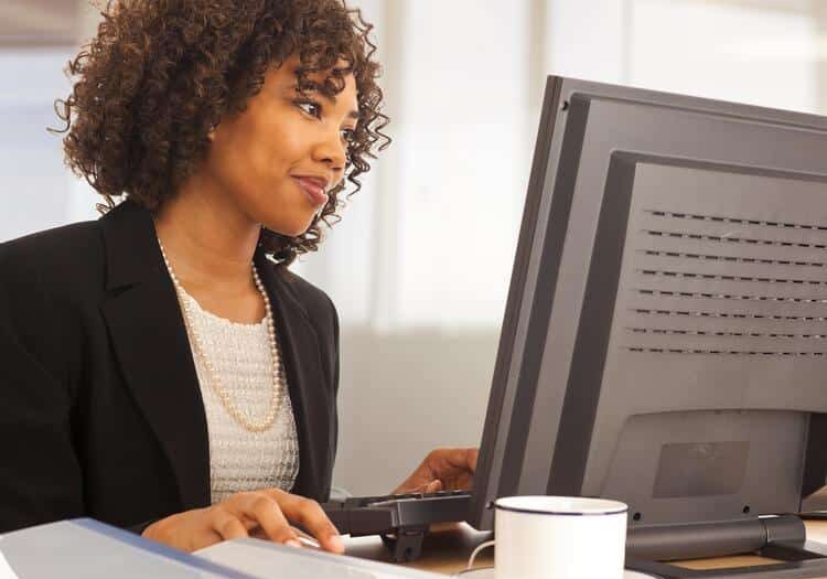 Young businesswoman using computer at desk indoors office building