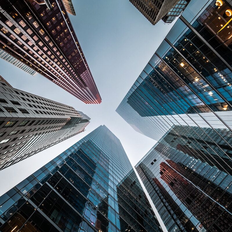 Business and finance concept, looking up at high rise office building architecture in the financial district of a modern metropolis.