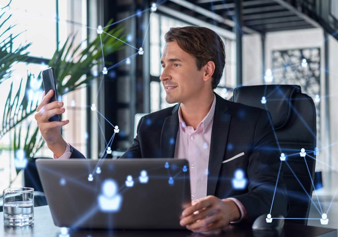 property manager man smiling while starting a computer accessing grace hill's intelligence+