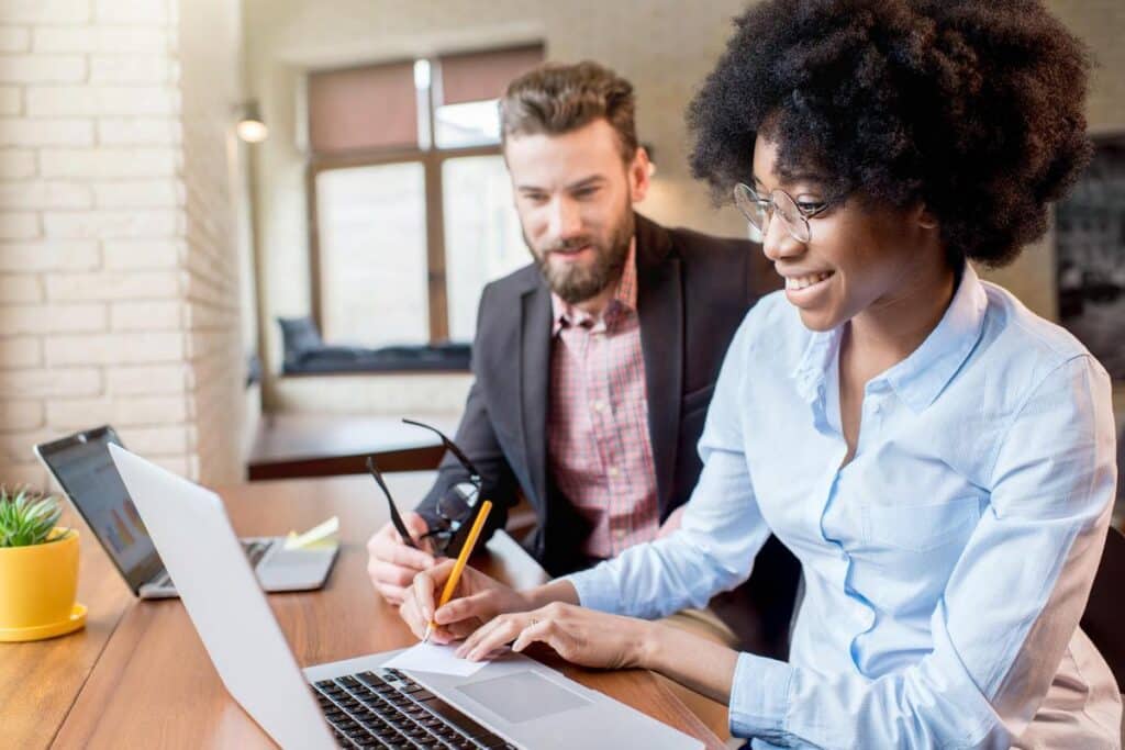 Property managers working on their properties policy compliance onlaptop indoors