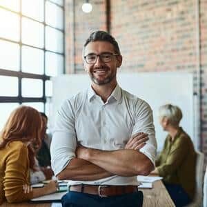 Cropped shot of a property management risk and compliance director standing in the property with his arms folded looking confident and smiling at the camera.